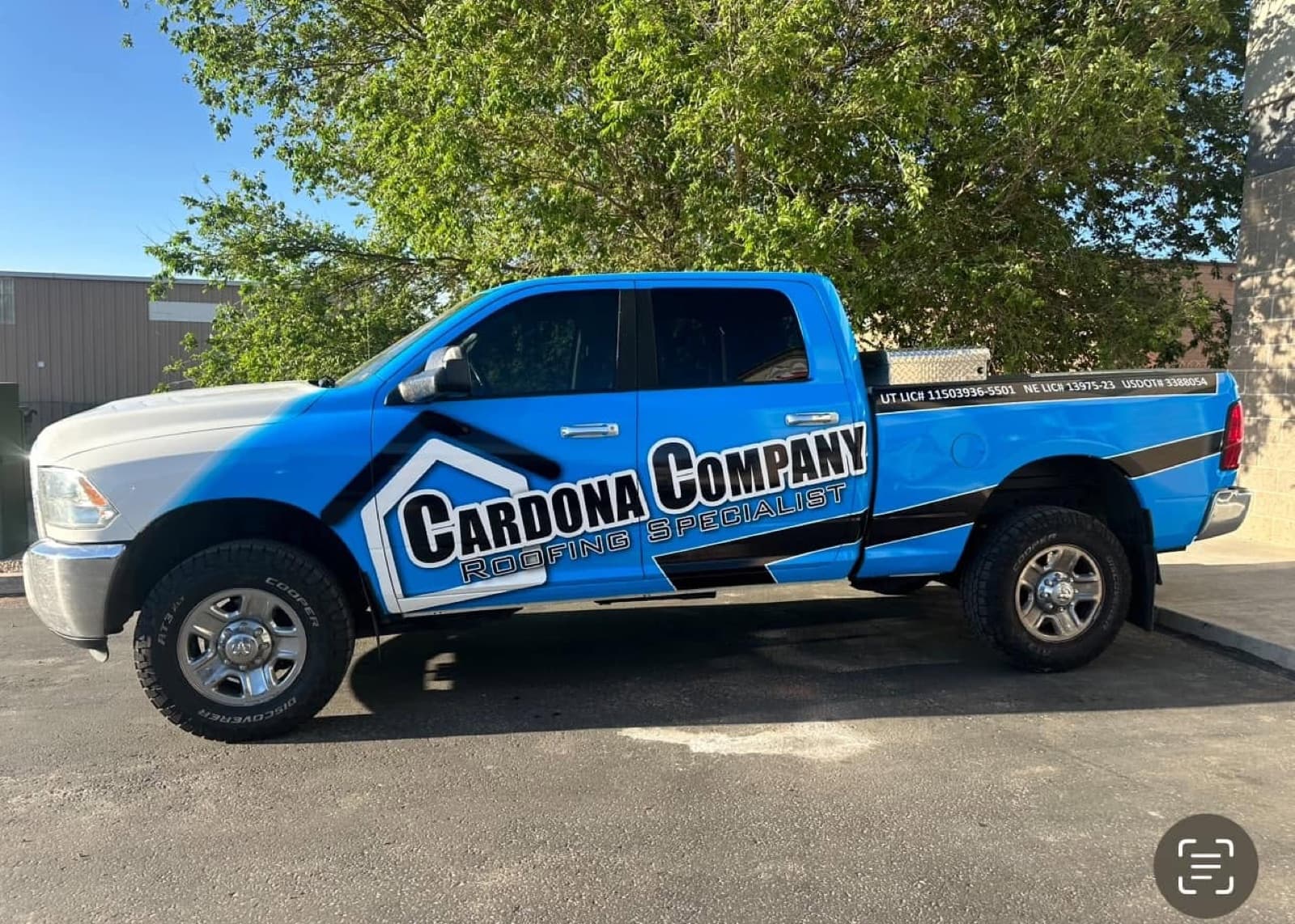 The branded blue Cardona Company roofing truck parked on the job