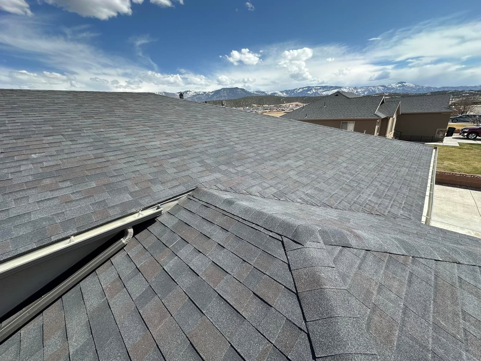 Charcoal shingle rooftop with a wide view of snow-capped mountains above Cedar City, Utah